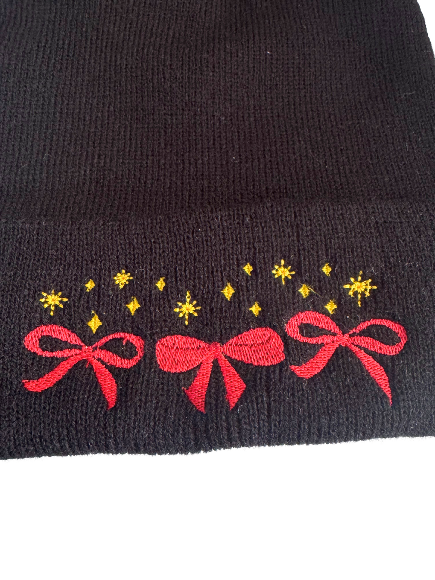 Black beanie with machine-embroidered red bows and golden stars in Chiefs colors.

