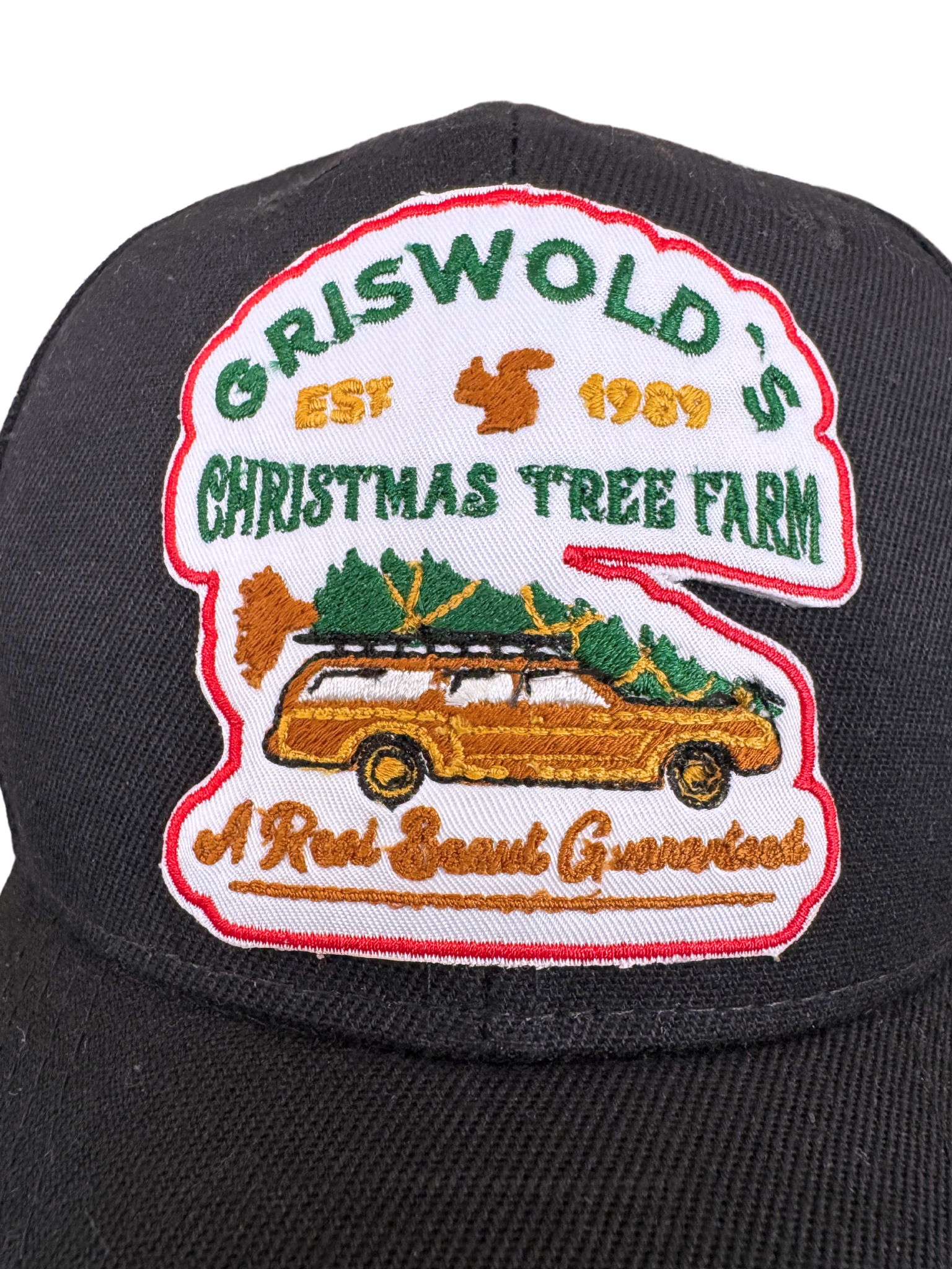 Griswold's Christmas Tree Farm black hat featuring an embroidered patch with a station wagon carrying a Christmas tree, inspired by National Lampoon’s Christmas Vacation.

