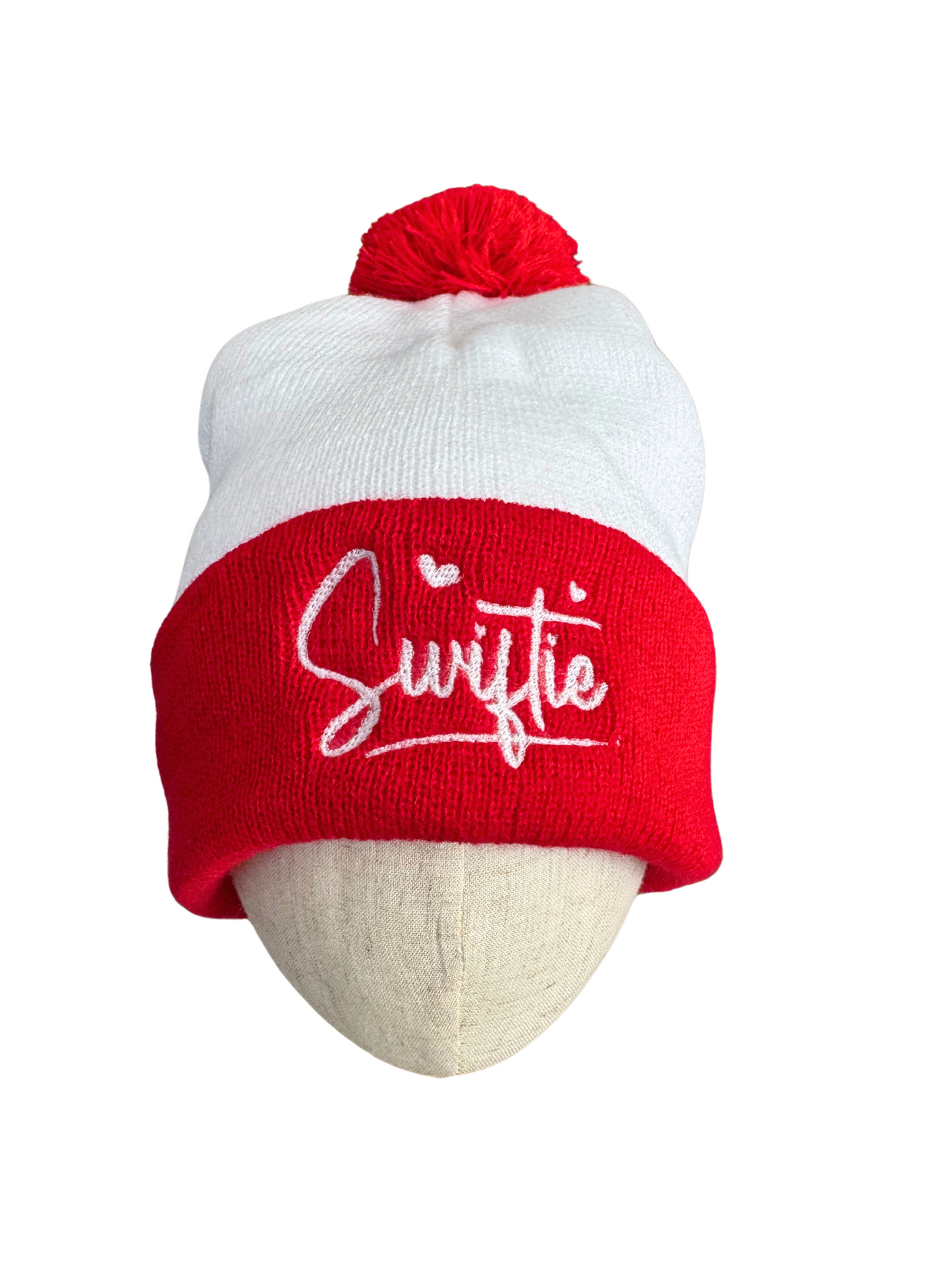 Red and white "Swiftie" beanie with pom, featuring white embroidery.