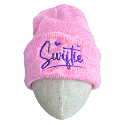 Pink "Swiftie" embroidered beanie with purple hearts design, ideal for music fans.