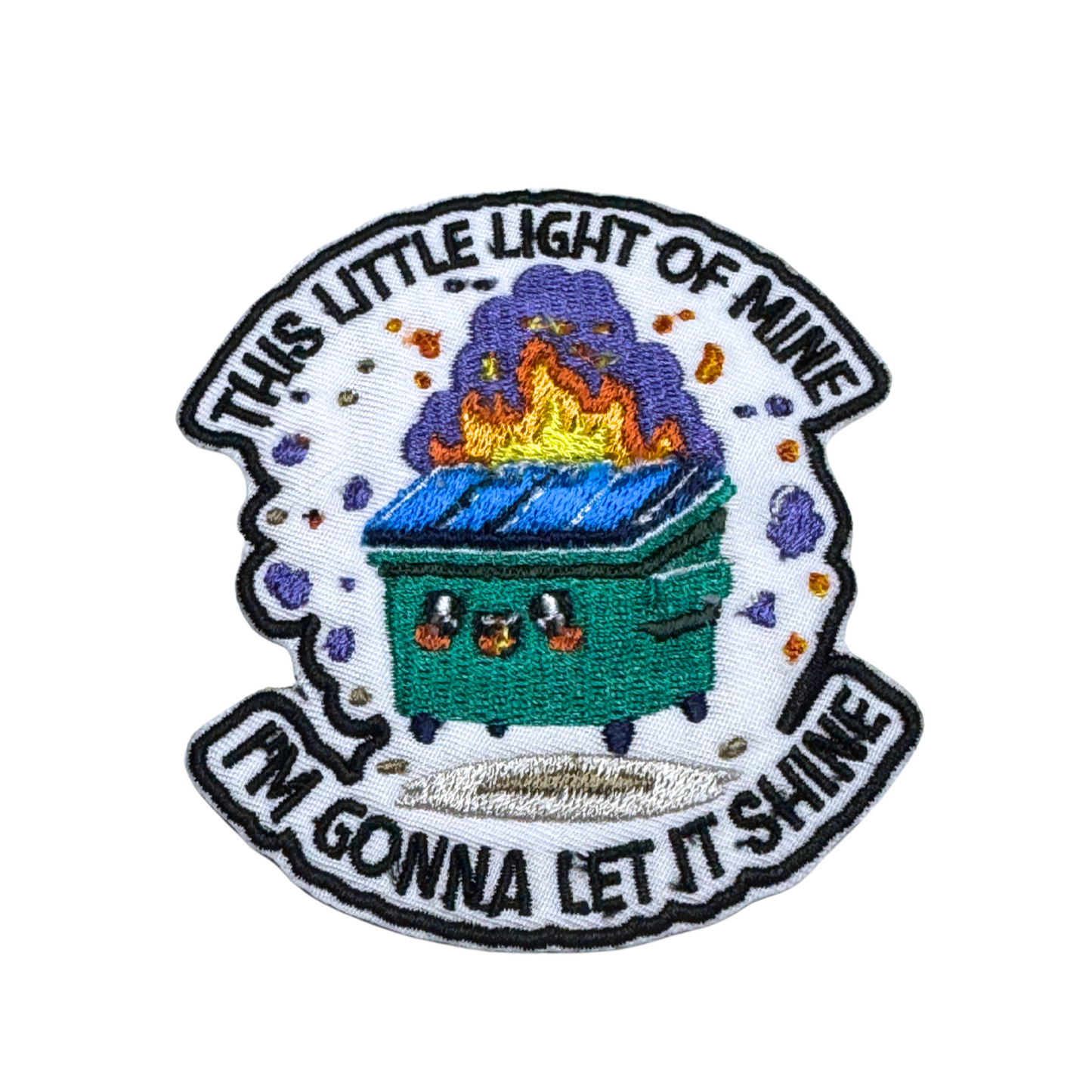 Close-up embroidered patch featuring a burning dumpster with the text "This Little Light of Mine, I'm Gonna Let It Shine."
