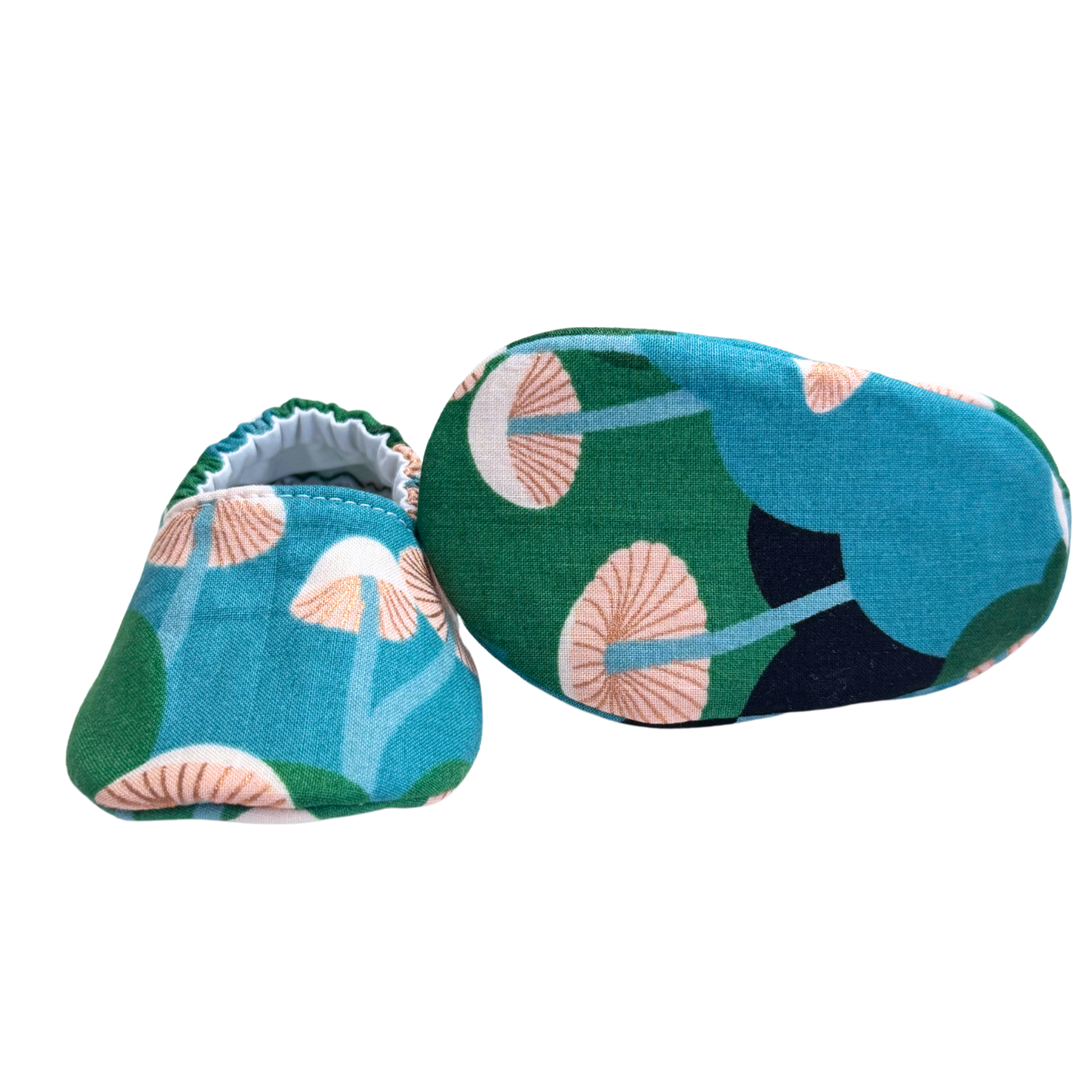 Bottom view of forest mushroom baby moccasins, highlighting the lightweight, vegan materials and soft soles designed for newborn foot development.

