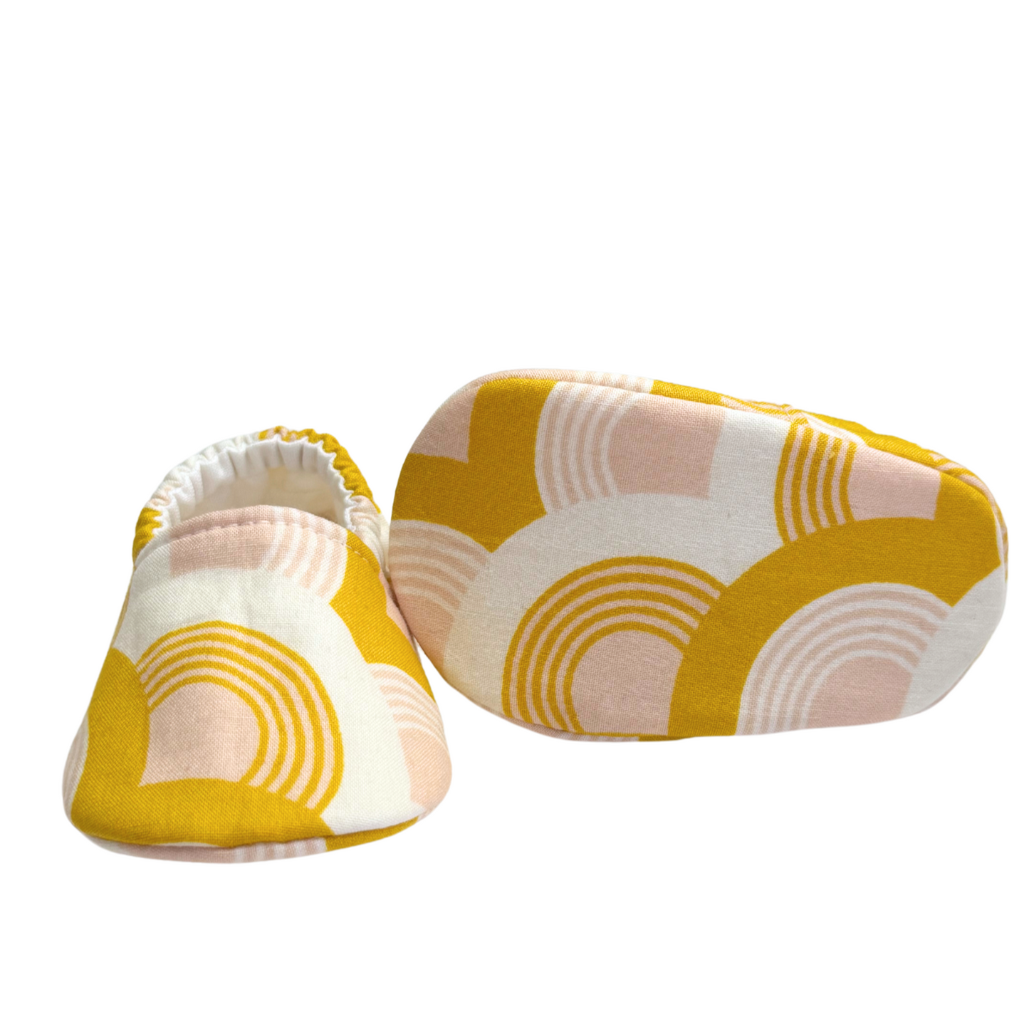 Bottom view of golden rainbow baby moccasins, highlighting the soft, flexible soles designed for early foot development and all-day comfort.

