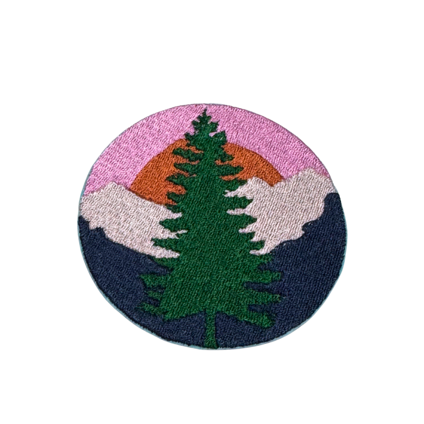 Embroidered patch featuring a tall green pine tree set against a mountain landscape with a pink, orange, and blue sunset sky.
