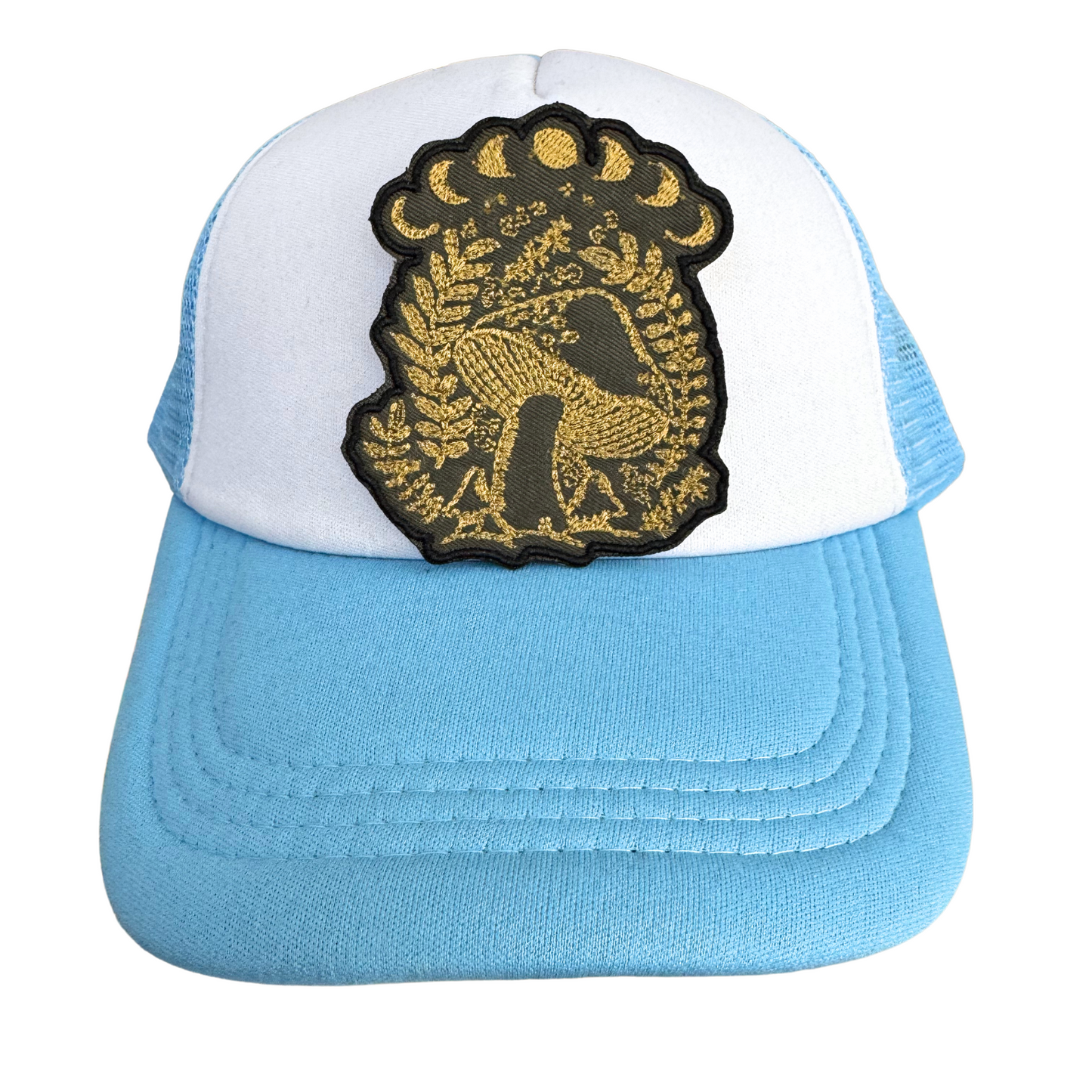 Blue and white trucker hat styled with the Golden Mystical Mushroom Moon Phase patch, perfect for celestial and nature-inspired looks.
