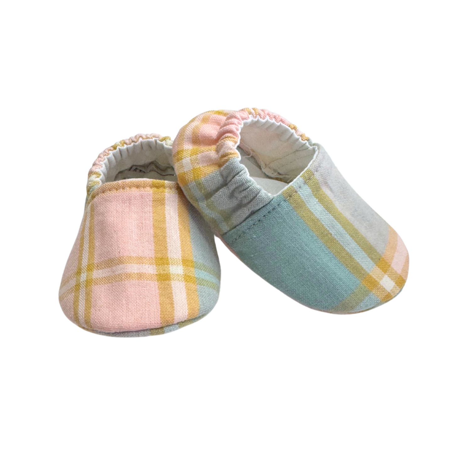 Side view of pastel plaid baby moccasins, showing soft, breathable vegan fabric and a stay-on elasticized back for a secure fit.