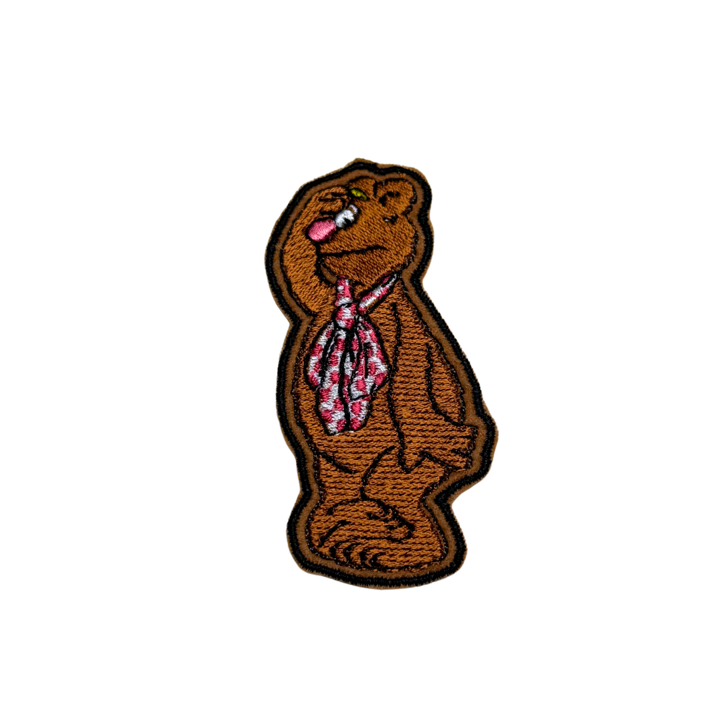 Embroidered patch featuring a brown bear wearing a patterned tie, standing upright with a comedic expression.
