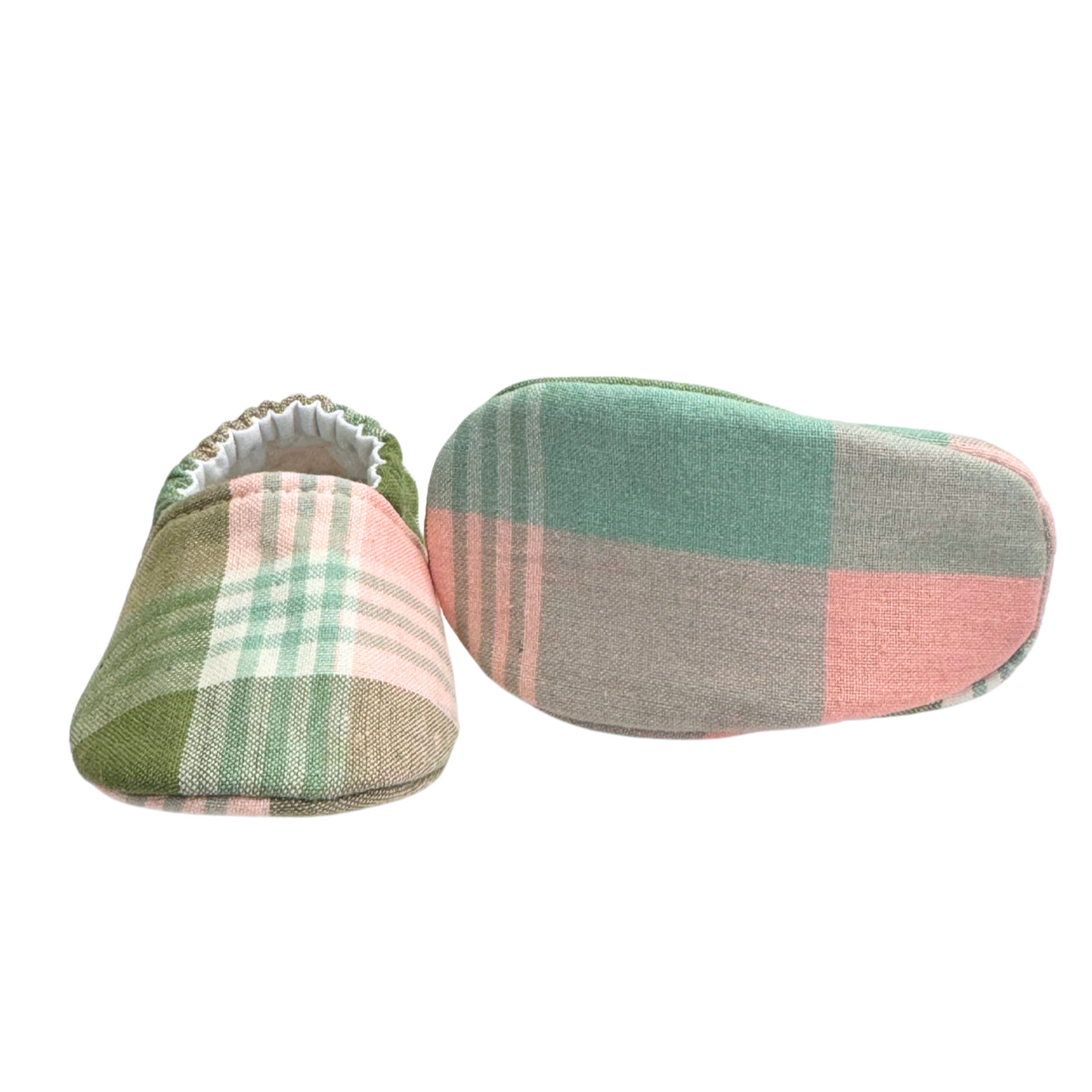 Bottom view of sage plaid baby moccasins, highlighting the soft, lightweight sole designed for newborn foot development and all-day comfort.

