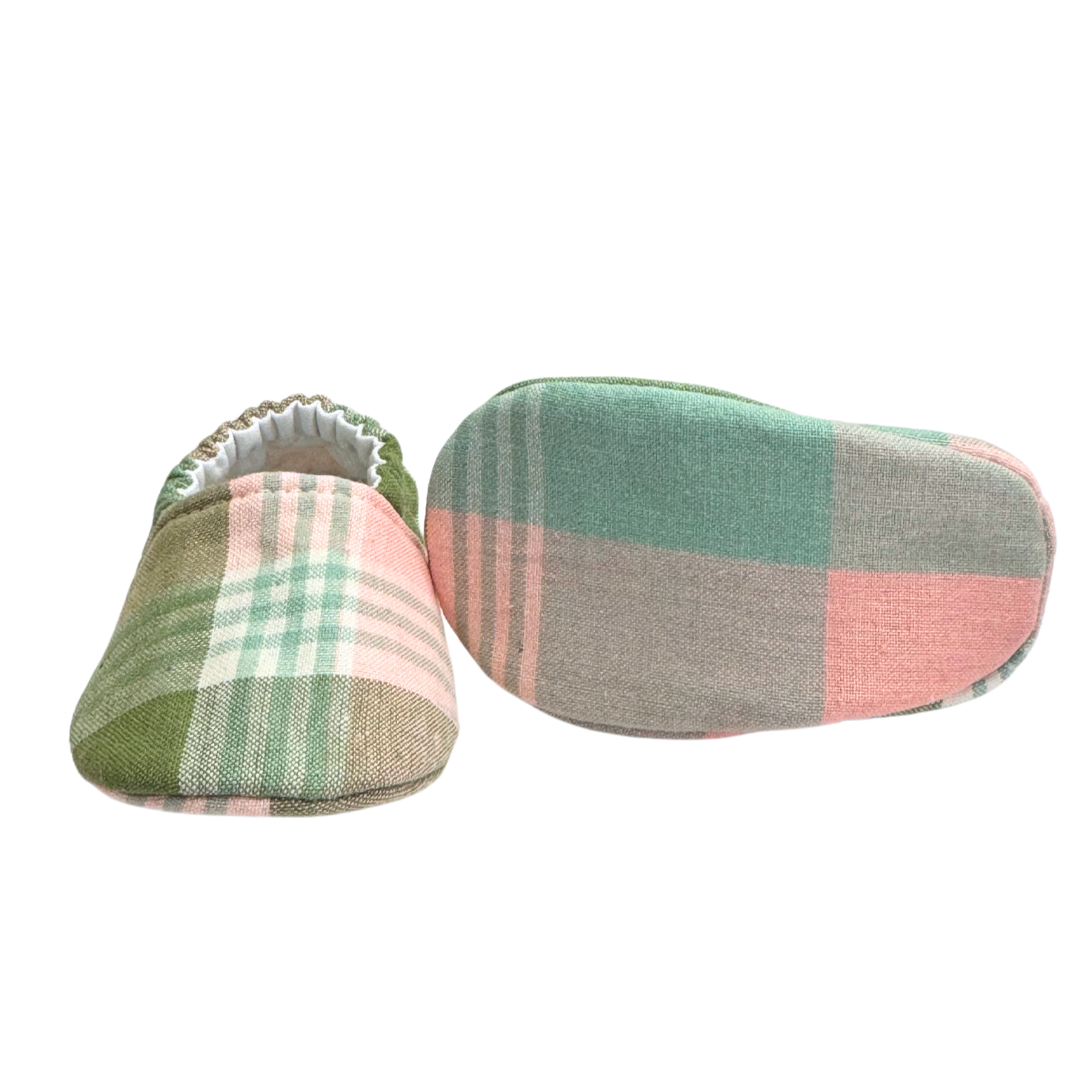 Bottom view of sage plaid baby moccasins, highlighting the soft, lightweight sole designed for newborn foot development and all-day comfort.

