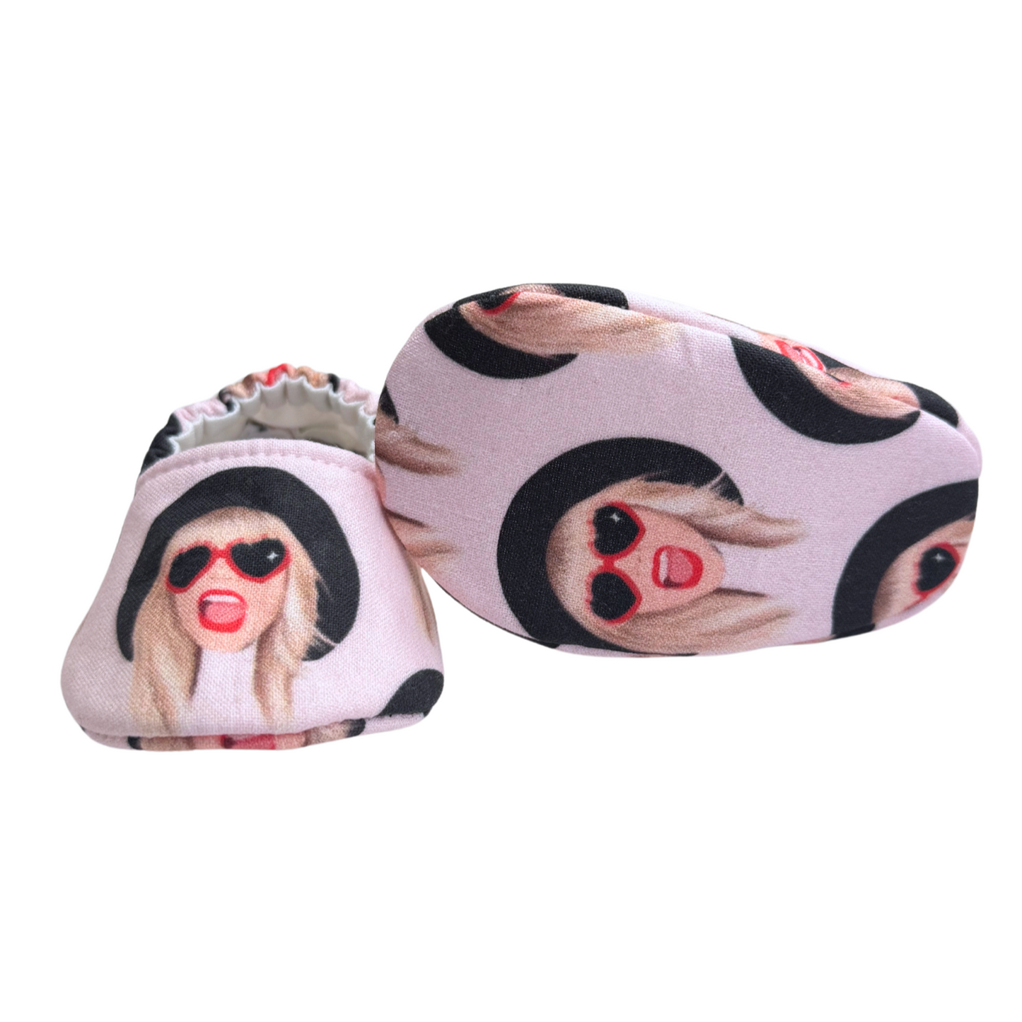 Bottom view of Taylor Swift baby moccasins, featuring a vibrant pink print with a music-inspired theme, perfect for newborns and Swiftie parents.

