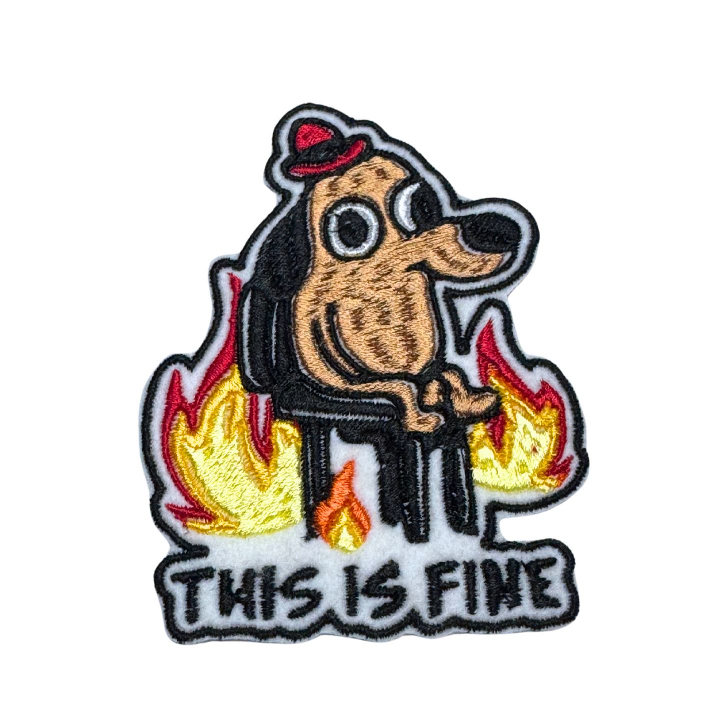 Close-up embroidered "This Is Fine" meme patch featuring a dog surrounded by flames.
